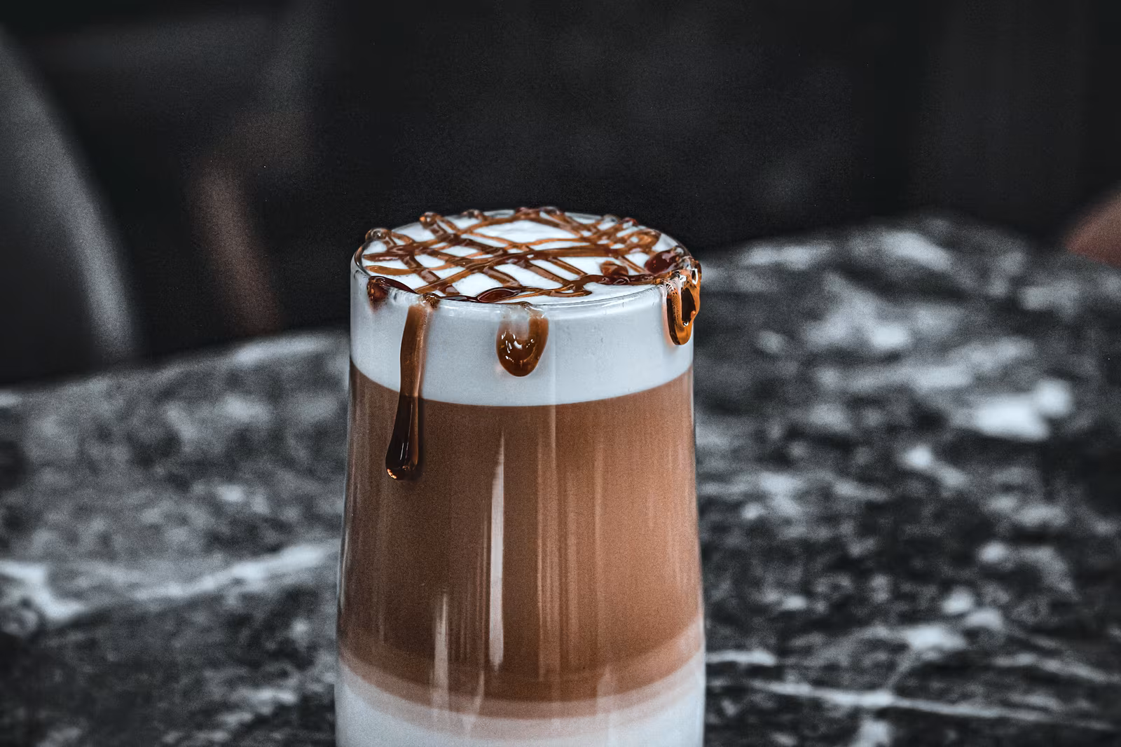A coffee drink with chocolate around the rim of the glass.