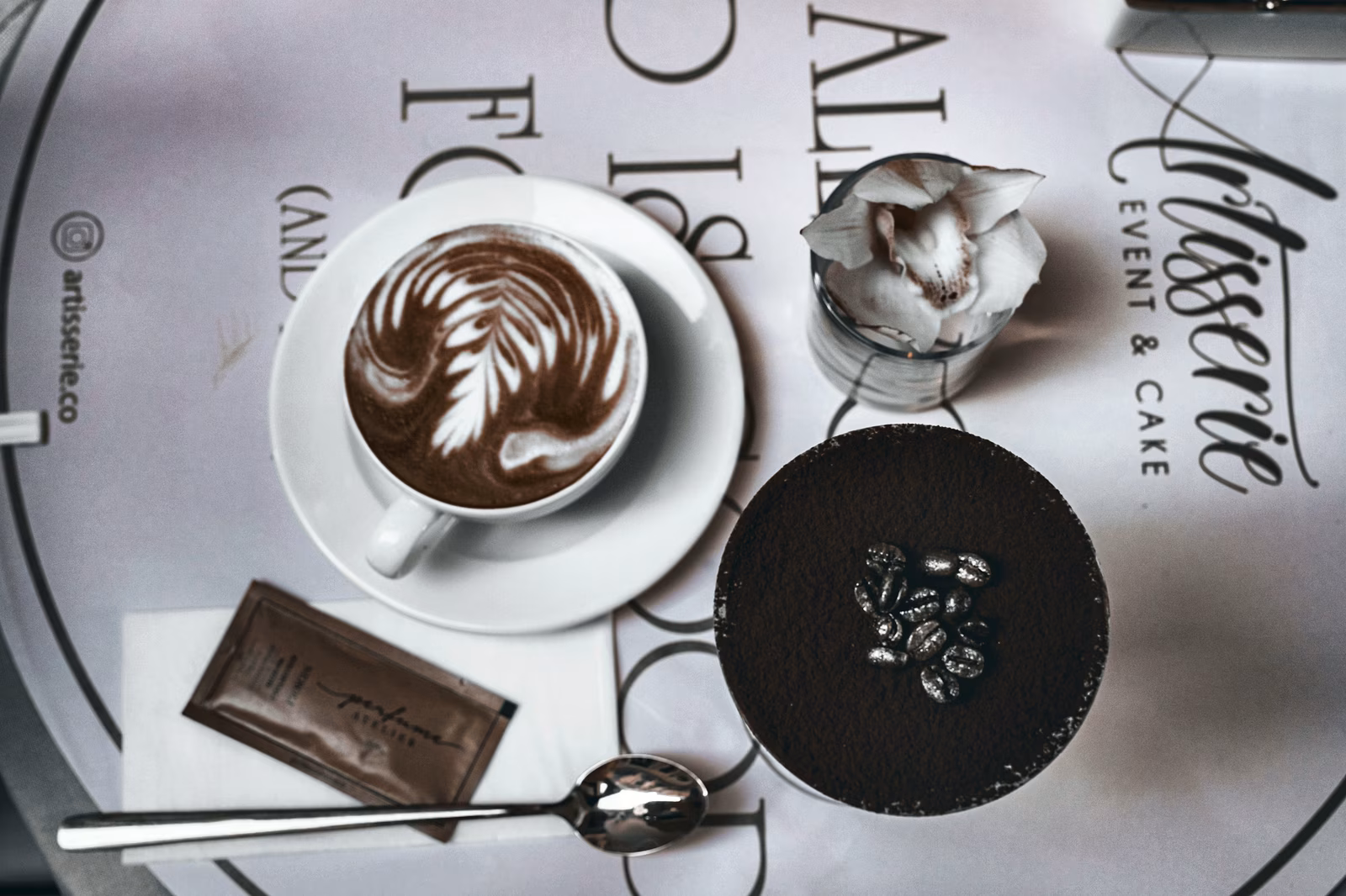 Coffee and chocolate on a table, viewed from above.