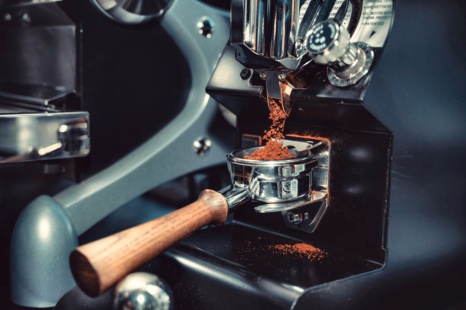 Een koffiemolen en portafilter bij een espressomachine.