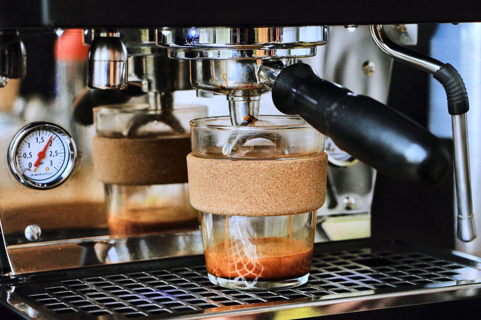 Espresso flowing from a portafilter into a glass.