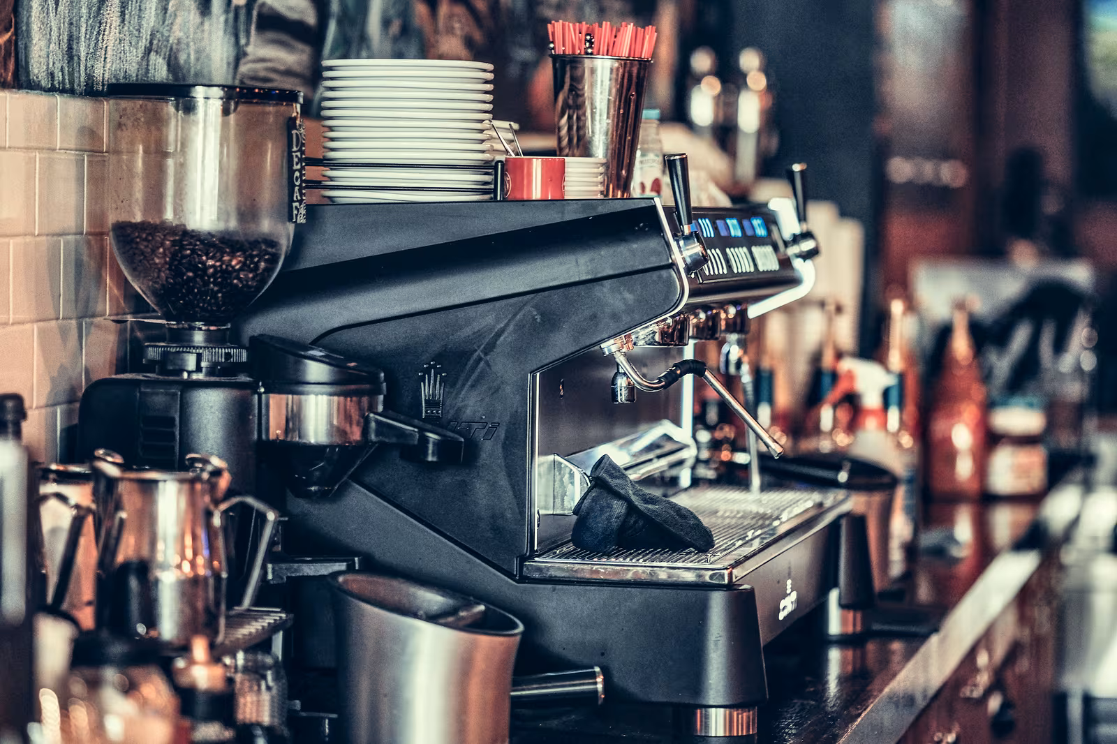 Een espressomachine met kopjes en bereidingsgereedschap.