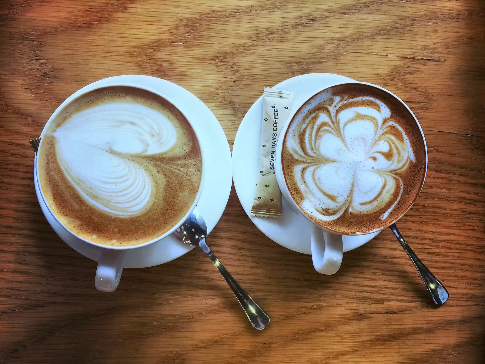Twee koppen koffie met verschillende patronen in het melkschuim.
